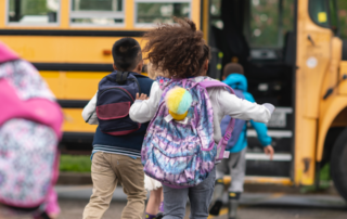 children running to a school bus